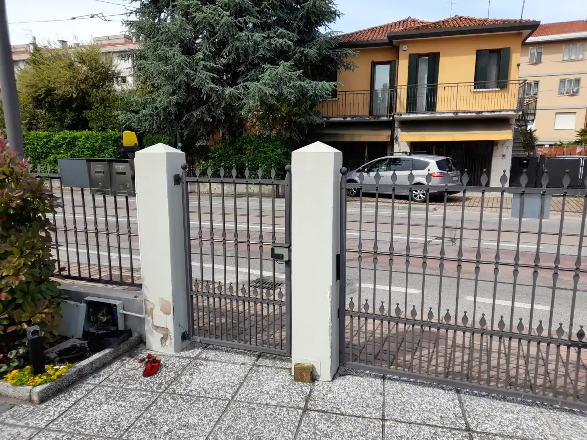 Cancello automatico con pilastri e motori a battente